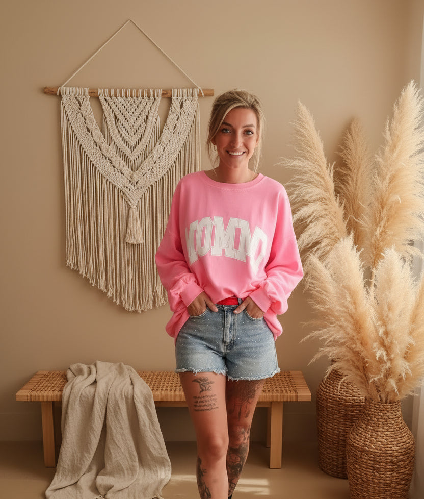 Boho-Luxe Look: Rosa Sweatshirt aus Baumwolle und Blue Denim Shorts kombiniert mit Makramee-Deko.