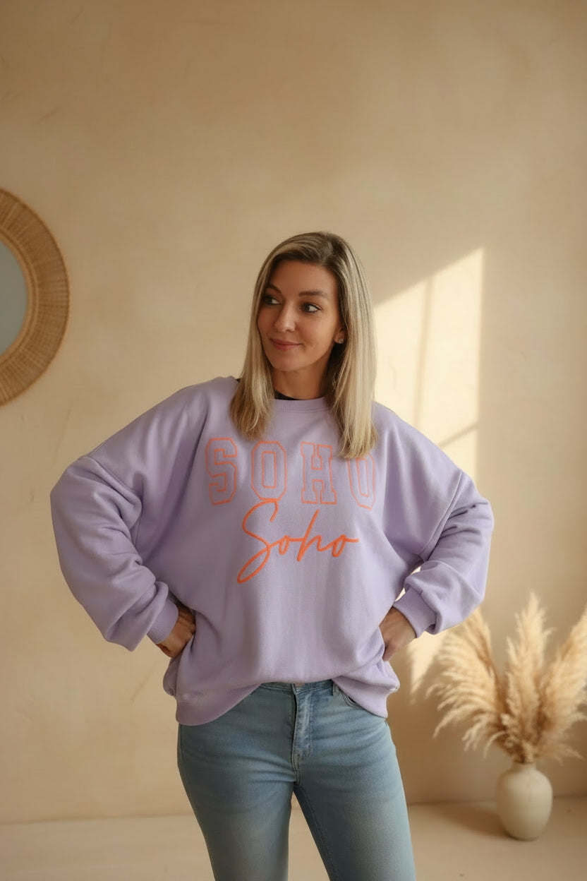 SOHO Sweatshirt Damen – Frontansicht lässige Pose orangener Statement-Print Lavendel