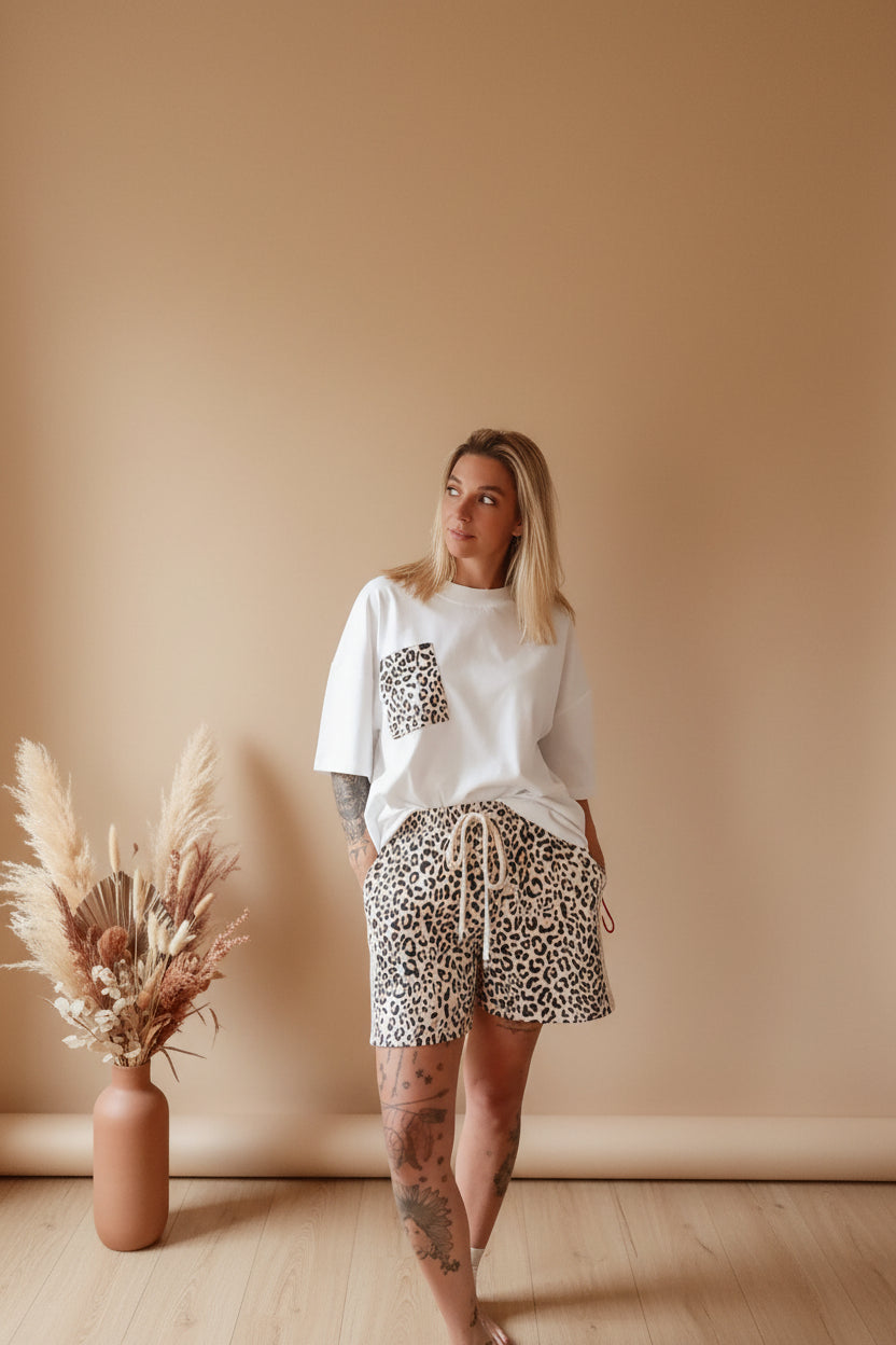 Boho-Luxe Set: Weißes T-Shirt mit Leopardenprint-Tasche und passende Shorts aus weichem Stoff.