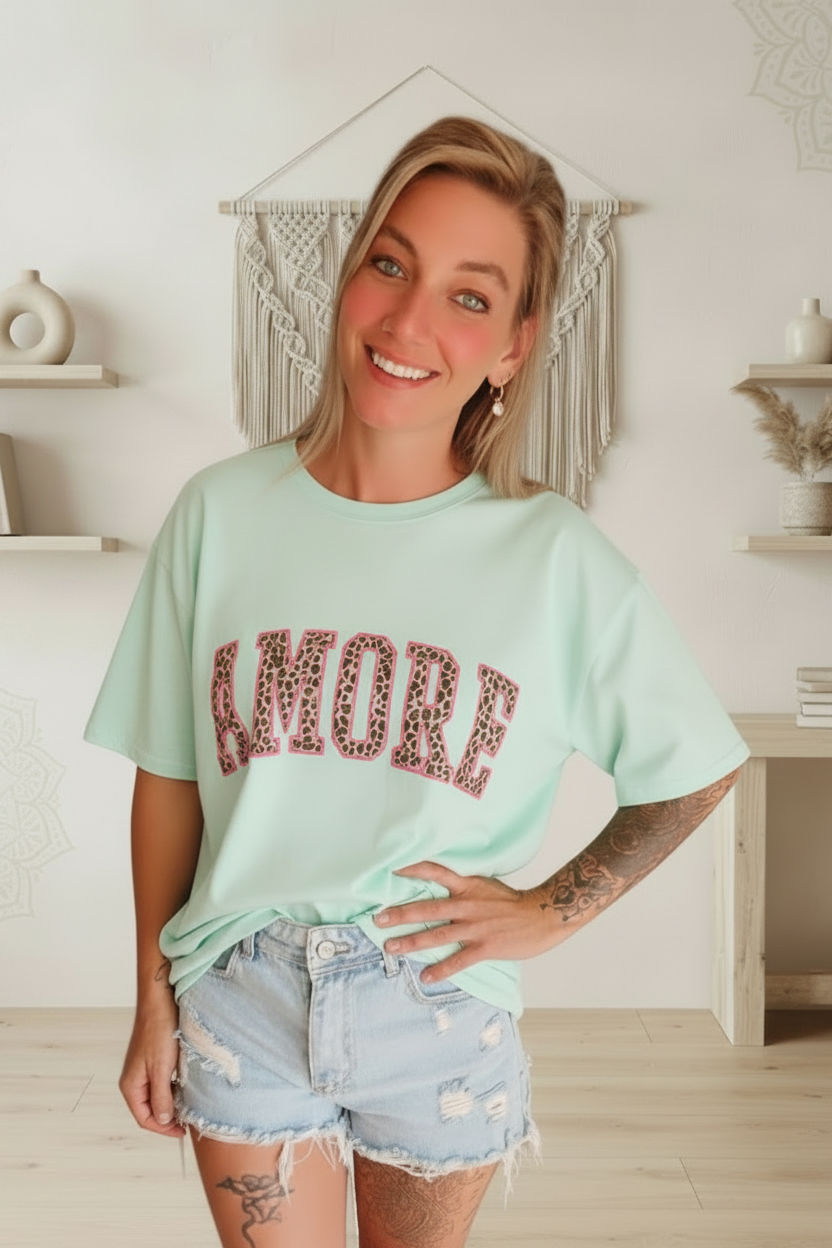 Mintgrünes Boho-Luxe T-Shirt mit Leopardenprint-Schriftzug und helle Denim-Shorts.
