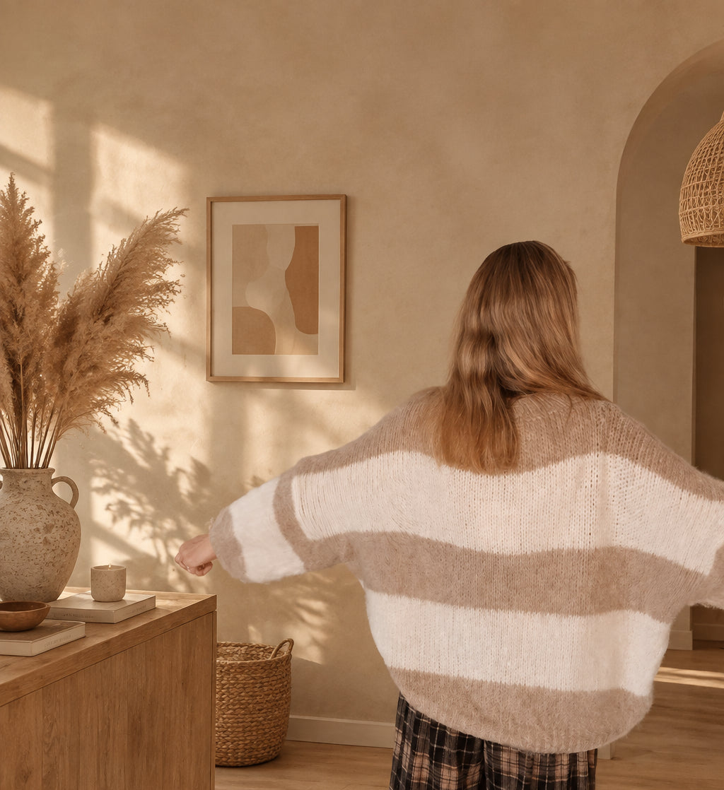 Beige-creme gestreifter Damen-Strickpullover in seitlicher Ansicht mit Blick auf Ärmel und lockeren Schnitt