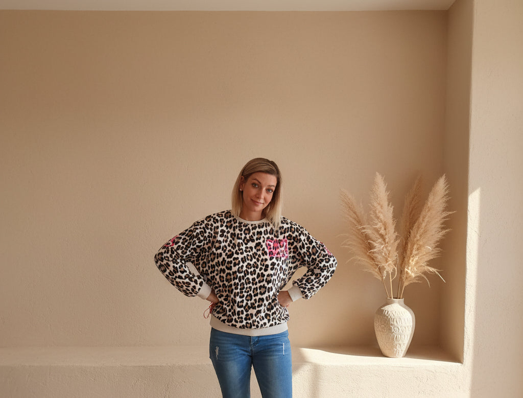 Vorderansicht eines Leo-Pullovers für Damen mit pinkem NY-Schriftzug