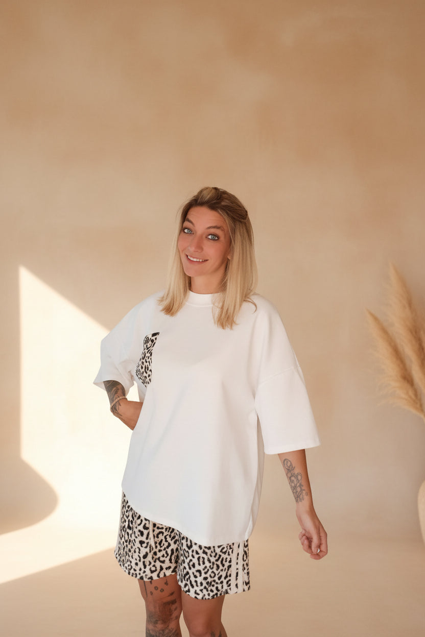 Boho-Luxe Outfit: Weißes Oversize-T-Shirt aus Baumwolle und Shorts mit Leopardenmuster.