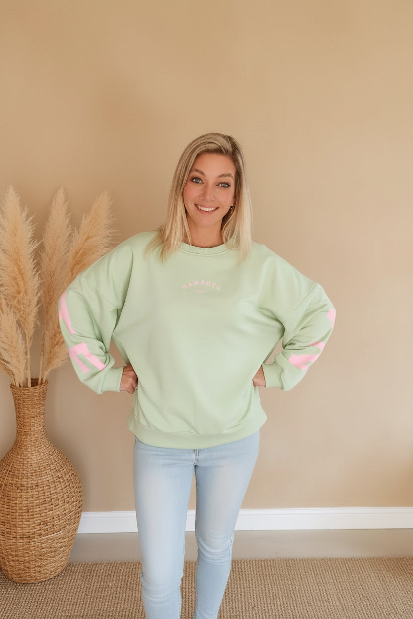 Namaste Sweater Mint Rosa Seitenansicht – Oversized Fit, rosa Schriftzug am Ärmel