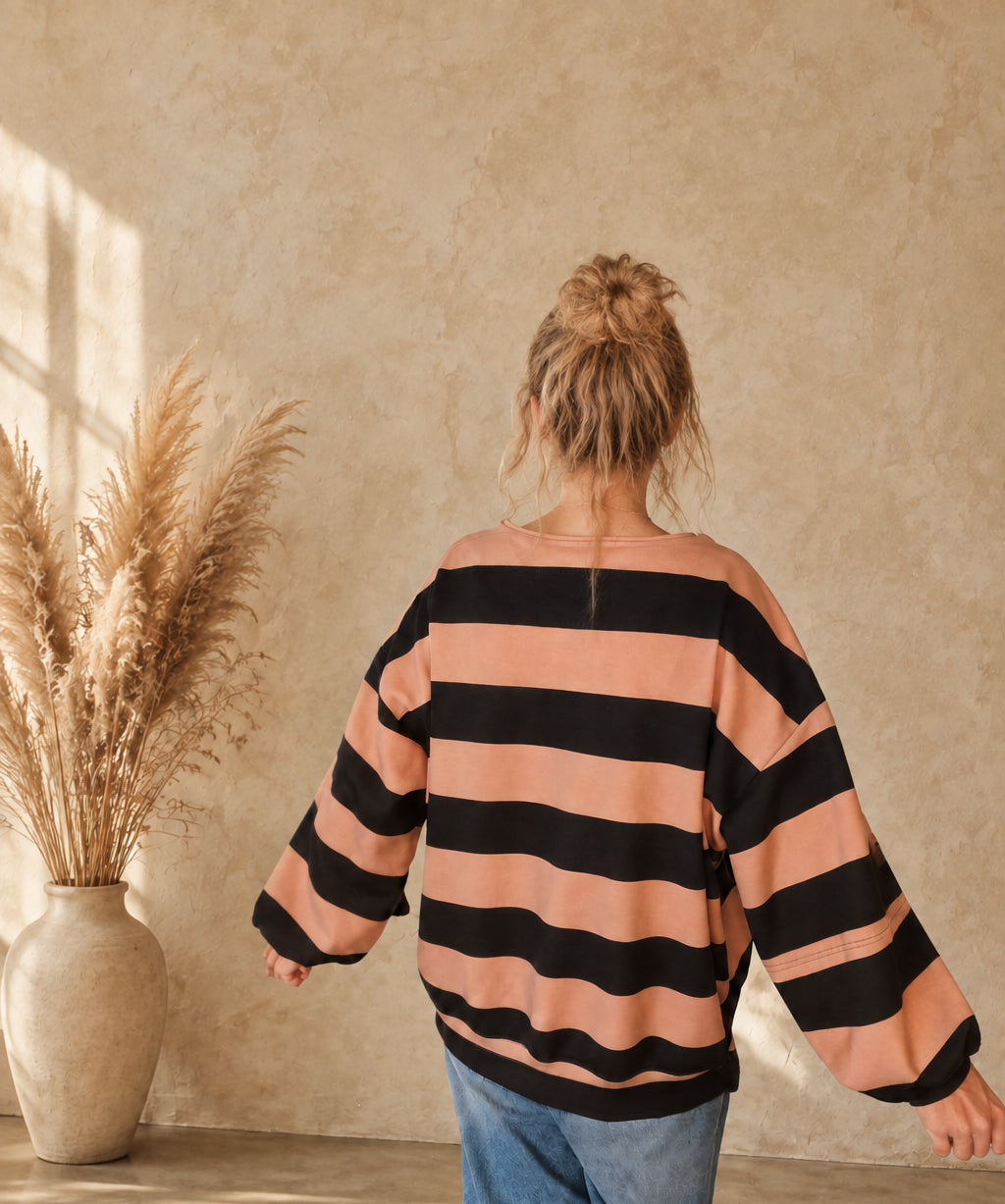 Rückansicht des Damen-Sweatshirts in Camel und Schwarz mit breiten Querstreifen und weiten Ärmeln.