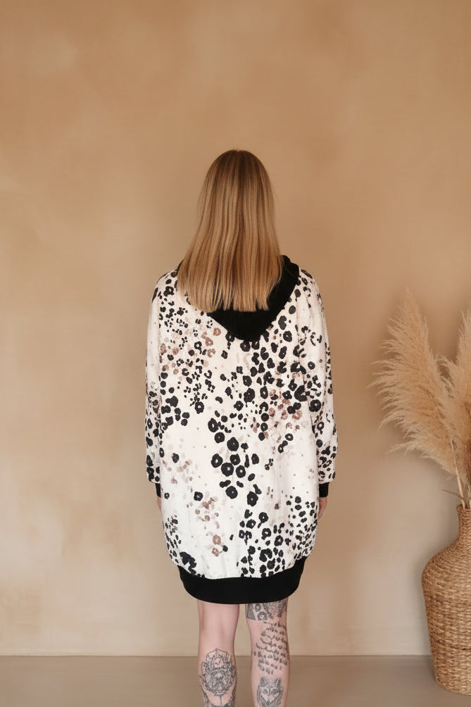 Rückenansicht einer Frau in einem Boho-Luxe Oversize-Sweatshirt mit Leopardenmuster in Schwarz-Beige.